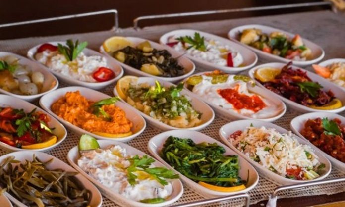 Mezelerin Sofralardaki Yeri ve Lezzet Sırları Mezeler, yemek kültürünün en zarif ve çeşitli öğelerinden biridir. Türkiye başta olmak üzere Akdeniz ve Ortadoğu mutfaklarında mezeler, sofraların vazgeçilmez bir parçası olarak yer alır. Tarih boyunca mezeler, hem besin hem de sosyal açıdan önem taşımış, sofraları zenginleştiren küçük lezzetler olarak kabul edilmiştir. Konulu bir haber görseli.