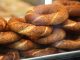 Simit, Osmanlı döneminden günümüze kadar gelen köklü bir geçmişe sahiptir. İlk olarak saray mutfaklarında farklı un karışımlarıyla yapılan bu lezzet, zamanla halk arasında yaygınlaşarak günlük yaşamın bir parçası haline gelmiştir. Özellikle 16. yüzyıldan itibaren İstanbul’da simit fırınlarının açılmasıyla birlikte, bu eşsiz yiyecek şehir kültürünün önemli bir unsuru olmuştur.