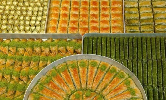 Sofralarda Baklava ve Tatlılar Türk mutfağının en ünlü tatlılarından biri olan baklava, sofralarda özel bir yere sahiptir. İnce açılmış hamur katmanları, bol ceviz veya fıstık içi ve şerbetin muhteşem uyumu, baklavayı hem gözlere hem de damaklara hitap eden bir tatlı haline getirir. Baklava, sadece Türkiye’de değil, dünya genelinde de sevilen ve takdir edilen bir lezzettir. Sofralarda baklava ve diğer tatlılar, kutlamaların, özel günlerin ve misafirliklerin vazgeçilmez unsurlarındandır. Konulu bir haber görseli.