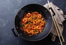 Woklama, kökeni Çin mutfağına dayanan ve asırlardır kullanılan bir pişirme tekniğidir. Yüksek ateş ve özel tasarlanmış derin tavalarda yapılan bu yöntem, kısa sürede yüksek ısı ile yemeklerin hazırlanmasını sağlar. Bu teknik, sadece hız değil aynı zamanda malzemelerin tazeliğini ve besin değerini korumasıyla da öne çıkar. Özellikle sebzelerin parlak rengini, etlerin ise sulu dokusunu koruyabilmesi, woklamanın diğer pişirme yöntemlerinden ayrılmasını sağlar. Konulu bir haber görseli.