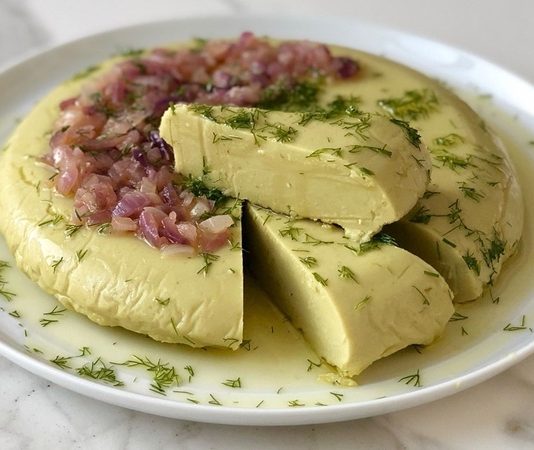 Fava, özellikle Ege mutfağının sevilen mezelerinden biridir ve hem lezzeti hem de besleyici özelliği ile öne çıkar. Fava, ezilmiş bakla, zeytinyağı ve limon ile hazırlanan, hafif ama besleyici bir mezedir. İçerdiği bakla, protein ve lif açısından zengin olduğu için hem tokluk hissi sağlar hem de sindirim sistemini destekler. Limon ve zeytinyağı, ezmenin aromasını güçlendirirken, vücuda sağlıklı yağ ve vitamin kazandırır. Konulu bir haber görseli.