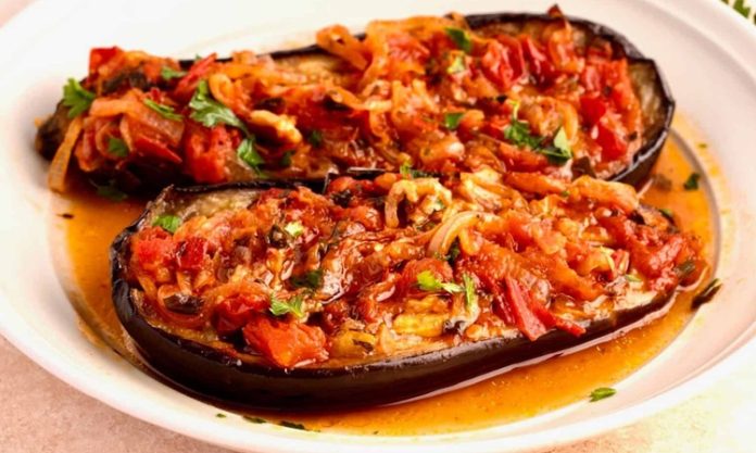 Türk mutfağının klasik zeytinyağlı lezzetlerinden biri olan imam bayıldı, hem hafif hem de besleyici bir yemek olarak bilinir. Osmanlı döneminden günümüze uzanan bu tarif, özellikle patlıcanın közlenmesi ve zeytinyağı ile buluşmasıyla ortaya çıkar. Tarih boyunca hem saray sofralarında hem de halk mutfaklarında hazırlanmış olan imam bayıldı, kültürel bir miras olarak önem taşır. Konulu bir haber görseli.