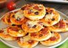 Mini pizza, adından da anlaşılacağı üzere standart pizzalardan daha küçük boyutlarda sunulan, özellikle aperatif veya atıştırmalık olarak tercih edilen bir pizza türüdür. Bu pizza türü, küçük porsiyonları sayesinde hem çocuklar hem de hızlı bir atıştırmalık arayan yetişkinler arasında oldukça popüler hale gelmiştir. Konulu bir haber görseli.