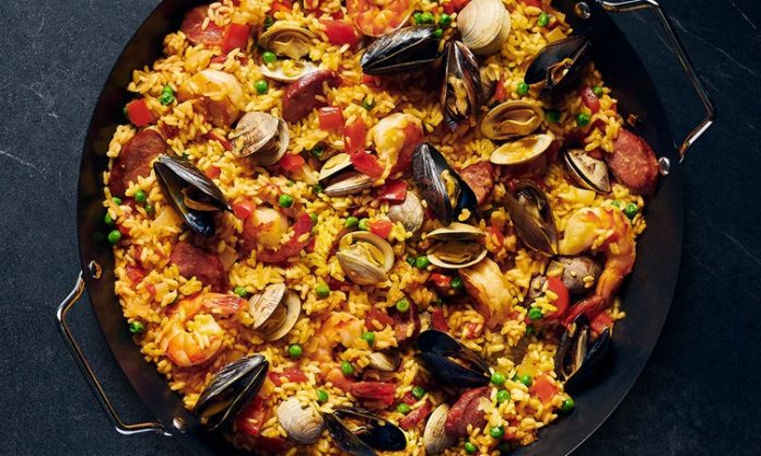 Paella İspanya Mutfağının Renkli Lezzeti Paella, İspanya’nın en bilinen yemeklerinden biri olarak dünya mutfağında önemli bir yere sahiptir. Özellikle Valencia bölgesinde ortaya çıkan bu yemek, zamanla tüm ülkeye ve oradan da dünyaya yayılmıştır. Tarihi 15. yüzyıla kadar uzanan paella, köylülerin tarlalarda buldukları malzemeleri bir araya getirerek pişirdikleri pratik bir yemek olarak doğmuştur. Konulu bir haber görseli.