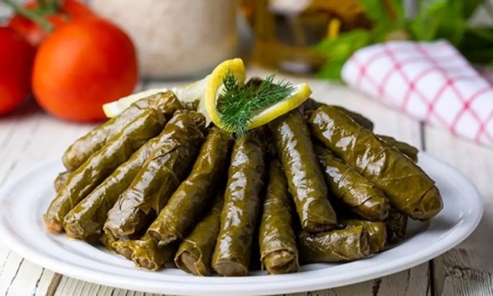 Zeytinyağlı yaprak sarma, Türk mutfağının en sevilen geleneksel lezzetlerinden biridir. Özellikle meze olarak sofralarda sıkça yer alır ve hem hafif hem de besleyici bir alternatif sunar. Yaprak sarması, sadece Türkiye’de değil, Orta Doğu ve Balkan mutfaklarında da farklı yorumlarla hazırlanır. Konulu bir haber görseli.