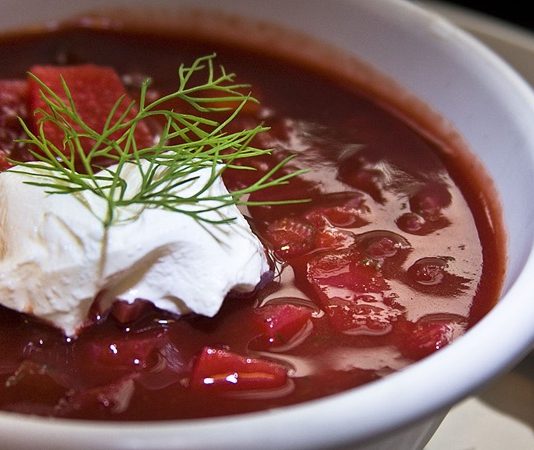 Borscht Doğu Avrupa’nın Kırmızı Lezzeti Dünya Mutfağında Yükseliyor Doğu Avrupa mutfağının en ikonik çorbalarından biri olan Borscht, son yıllarda gastronomi dünyasında yeniden popülerleşiyor. Özellikle kırmızı pancarın yoğun rengini ve tatlı-ekşi aromalarını bir araya getiren bu çorba, hem geleneksel sofraların hem de modern restoran menülerinin vazgeçilmez bir parçası hâline geldi. Besleyici içeriği ve doyurucu yapısıyla bilinen Borscht, sadece Doğu Avrupa’da değil, dünya çapında da tanınan bir lezzet olarak öne çıkıyor. Türkiye’de de son yıllarda artan gastronomi ilgisi sayesinde bu çorba mutfaklarda yerini almış durumda. Konulu bir haber görseli.