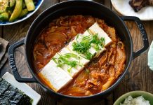 Güney Kore mutfağının en ikonik çorbalarından biri olan Kimchi Jjigae, son yıllarda dünya genelinde hem restoran menülerinde hem de ev yapımı tariflerde popülerliğini artırıyor. Özellikle fermente lahana, baharatlı biber ve dengeli et suyu ile hazırlanan bu çorba, hem doyurucu hem de sağlık açısından zengin bir yemek olarak öne çıkıyor. Türkiye’de de gastronomi meraklılarının ilgisini çeken Kimchi Jjigae, Kore mutfağının globalleşmesinde önemli bir rol oynuyor. Lezzeti ve besleyici özellikleri sayesinde çorba severler için hem geleneksel hem de modern alternatifler sunuyor. Konulu bir haber görseli.