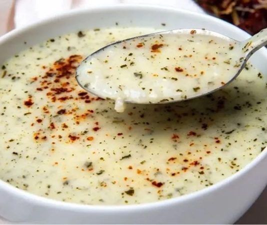 Yayla çorbasının kökeni, Anadolu’daki göçebe kültürlere ve özellikle hayvancılıkla geçinen topluluklara dayanıyor. Yoğurdun ana malzeme olması, çorbanın tarih boyunca kolay ulaşılabilir temel gıdalardan biri olduğunu gösteriyor. Eski Türk topluluklarında süt ürünlerinin yeri çok güçlü olduğu için, bu çorbanın ortaya çıkışı da oldukça doğal bir süreç olarak değerlendiriliyor. Tarihsel kaynaklarda yaylalarda yaşayan toplulukların uzun yolculuklar ve zorlu hava koşulları sırasında hem doyurucu hem de bağışıklık güçlendirici bir çorbaya ihtiyaç duyduğu belirtiliyor. İşte bu ihtiyacın karşılığı olarak Yayla çorbası yüzyıllar boyunca varlığını sürdürmüş durumda. Konulu bir haber görseli.