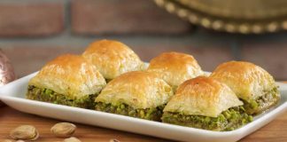 Geleneksel Lezzet Baklavanın Yükselen Popülaritesi ve Modern Dokunuşlarla Yeniden Şekillenen Yolculuğu Türkiye’nin en özel tatlılarından biri olan baklava, yüzyıllar boyunca hem coğrafyalara hem de kültürlere yayılan zengin bir mirasa sahip. Orta Asya’dan Anadolu’ya uzanan serüveniyle bugün dünyanın dört bir yanında tanınan bir lezzet hâline gelen baklava, Osmanlı mutfağından itibaren saray sofralarının vazgeçilmez tatlısı olarak kayıt altına alınmıştır. Bu süreçte tatlının yapım teknikleri geliştirilmiş, farklı yörelerde kendine has çeşitleri ortaya çıkmıştır. Gaziantep baklavası, bu tarihsel yolculukta en çok bilinen ve coğrafi işaret tesciline sahip örneklerden biridir. Konulu bir haber görseli.