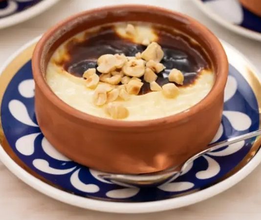 Türkiye’nin en köklü tatlılarından biri olan sütlaç, hem geleneksel hem modern sofralarda yerini korumaya devam ediyor. Tarihi Osmanlı mutfağına kadar uzanan bu hafif tatlı, son dönemde yapılan gastronomi festivalleri ve sosyal medya paylaşımlarıyla yeniden gündemin en popüler lezzetleri arasına girdi. Özellikle ev yapımı tariflerin yükselişi, doğal malzemelere olan ilginin artması ve pratik hazırlanışı, sütlaç talebini daha da artırıyor. Üstelik hem günlük tüketimde hem de özel günlerde tercih edilen bu tatlı, her yaş grubundan yoğun ilgi görüyor. Konulu bir haber görseli.