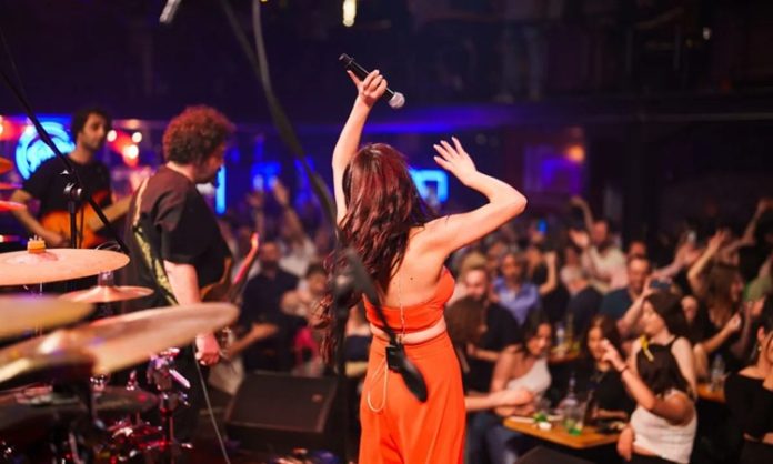 Şehir yaşamının hızına kısa bir mola vermek, müziğin ritmiyle nefes almak isteyenlerin ilk tercihlerinden biri canlı müzik mekanları oluyor. Bu mekânlar, yalnızca müzik dinlenen alanlar değil; aynı zamanda duyguların paylaşıldığı, anıların biriktiği ve sosyal bağların güçlendiği özel buluşma noktaları olarak öne çıkıyor. Farklı müzik türlerini bir araya getiren canlı müzik mekânları, her yaştan ve her zevkten insan için alternatifler sunuyor. Konulu bir haber görseli.